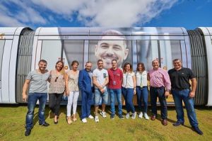 Representantes de Metrotenerife y Zona Comercial Tranvía posan junto al tranvía rotulado para promocionar el comercio. 